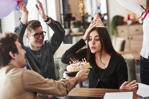 ognuna di queste candele deve smettere di accendersi con un solo respiro. uno dei dipendenti compie gli anni oggi. colleghi amichevoli decide di fare una sorpresa per lei foto