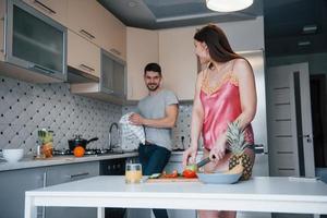 guardando con amore. giovane coppia nella cucina moderna a casa durante il fine settimana al mattino foto