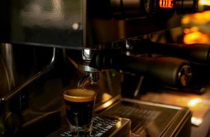 primo piano macchina da caffè professionale in caffetteria. caffettiera per caffè espresso, americano, latte e cappuccino. bancone bar della caffetteria. strumento moderno per barista. attività di servizi di bevande. foto