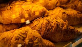 croissant appena sfornati nel vassoio nel negozio di caffè e panetteria. pasticceria al forno. croissant al burro francese per colazione. colazione continentale. pane gustoso fatto di lievito, pasta e burro. concetto di ora del brunch foto