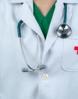 il medico indossa l'uniforme bianca e l'uniforme verde scrub all'interno. medico con stetoscopio appendere al collo. operatore sanitario. concetto di fiducia del paziente. foto