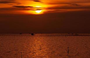 bellissimo tramonto sul mare. cielo e nuvole al tramonto scuri e dorati. sfondo della natura per un concetto tranquillo e pacifico. tramonto a chonburi, in tailandia. foto d'arte del cielo al tramonto. agricoltura in mare.