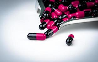 capsule rosa-nere sul vassoio del farmaco. resistenza ai farmaci agli antibiotici. assistenza sanitaria globale. capsule antimicrobiche. sfondo della farmacia. uso di farmaci antibiotici con ragionevole. industria farmaceutica. foto