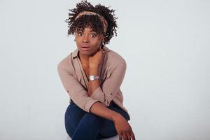 faccia sorpresa. bella ragazza afroamericana con i capelli ricci in studio con sfondo bianco foto