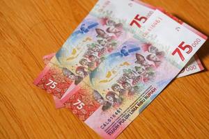 settantacinquemila rupie sul tavolo. banconote indonesiane foto