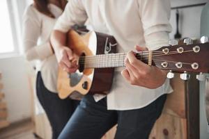 persone eleganti. vista ravvicinata. chitarrista che suona una canzone d'amore per la sua ragazza in cucina foto