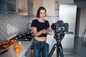 tenendo la pala di legno. ragazza nella cucina moderna a casa durante il fine settimana al mattino foto