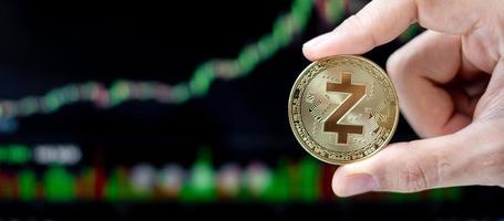 moneta di criptovaluta zcash dorata con sfondo grafico a candela, la cripto è denaro digitale all'interno della rete blockchain, utilizza la tecnologia e lo scambio Internet online. foto