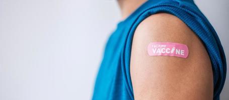 uomo che mostra una benda dopo aver ricevuto il vaccino covid 19. vaccinazione, immunità di gregge, effetti collaterali, dose di richiamo, passaporto vaccinale e pandemia di coronavirus foto