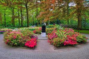 monumento tra fiori rosa, parco keukenhof, lisse in olanda foto