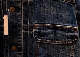 messa a fuoco selettiva sulla tasca della giacca di jeans denim nel negozio di abbigliamento. fondo di struttura della tasca della giacca di jeans. industria tessile. jeans moda e concetto di shopping. concetto di abbigliamento. Vendo giubbotto di jeans. foto
