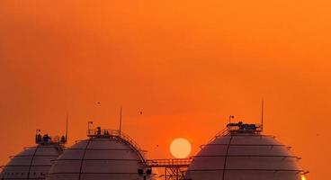 serbatoio di stoccaggio del gas industriale sul cielo al tramonto arancione. serbatoio di stoccaggio del gas naturale liquefatto o lng. serbatoio del gas sferico nella raffineria di petrolio. serbatoio di accumulo fuori terra. industria di stoccaggio del gas naturale. foto