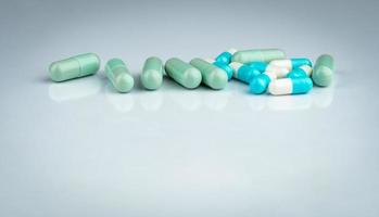 interazioni tra erbe e farmaci. pillola capsula verde e blu su sfondo bianco. erboristeria. industria farmaceutica. sfondo farmacia farmacia. farmaceutici. assistenza sanitaria globale. farmacologia. foto