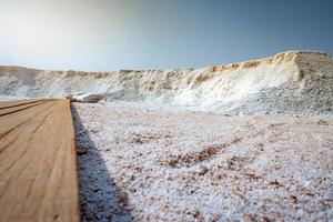 vista ad angolo basso della salamoia salina con cielo blu. mucchio di sale marino biologico vicino al magazzino. materia prima di sale industriale. sale dell'oceano. minerale di cloruro di sodio. viaggio estivo nel concetto di thailandia. foto