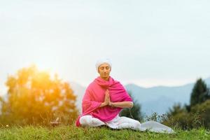 donna yoga sul parco verde foto