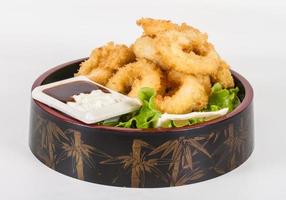 Anelli di calamari fritti in pastella con insalata verde foto