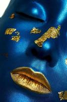 modello femminile con pelle blu e labbra dorate. trucco di Halloween foto