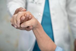 tenendosi per mano asiatica anziana o anziana signora anziana paziente con amore, cura, incoraggiamento ed empatia nel reparto ospedaliero di cura, concetto medico sano e forte foto