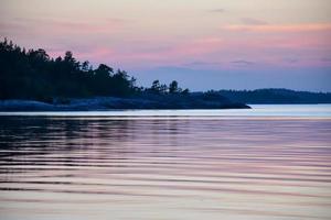 tramonto di sera viola blu su un lago nell'arcipelago svedese foto