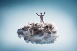 uomo vincente in piedi su una nuvola bianca. foto