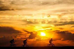 amici in gita in bicicletta al tramonto. stile di vita attivo, hobby del ciclismo. foto