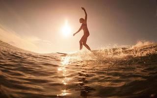 la ragazza con il surf all'alba foto
