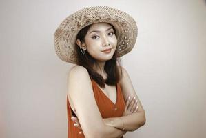 una giovane donna asiatica si tiene per mano incrociata con uno sguardo serio, sorridente e sicuro di sé. foto