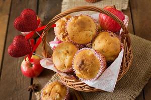 muffin alla frutta con noce moscata e pimento in un cesto di vimini su uno sfondo di legno foto