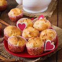 muffin alla frutta con noce moscata e pimento in un cesto di vimini su uno sfondo di legno foto