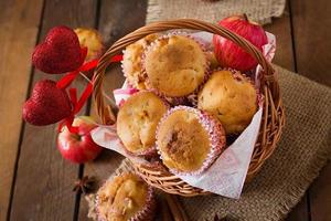 muffin alla frutta con noce moscata e pimento in un cesto di vimini su uno sfondo di legno foto