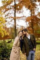 giovane coppia che cammina nel parco autunnale foto