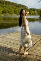 giovane donna che cammina sul molo di legno al lago calmo foto