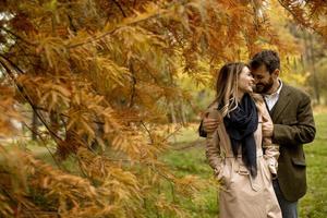 giovane coppia che cammina nel parco autunnale foto