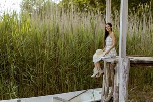 giovane donna rilassante sul molo di legno al lago calmo foto