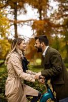 giovane coppia nel parco autunnale con bicicletta elettrica foto