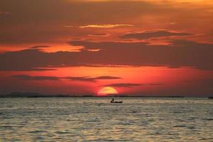 tramonto sul cielo rosso indietro nuvola serale sull'orizzonte mare foto