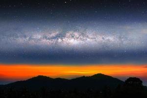 luce del tramonto del paesaggio notturno della via lattea sopra la collina della montagna della siluetta foto