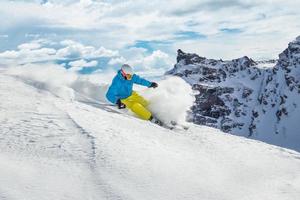 sciatore che scia in discesa in alta montagna foto