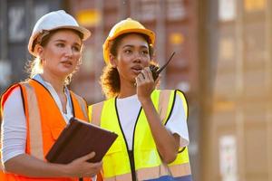 imprenditrice e logistica lavoratore donna che controlla la scatola dei contenitori e carica i prodotti nel computer dalla nave da carico al container. foto