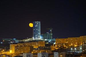 paesaggio urbano notturno con la luna nel cielo. foto