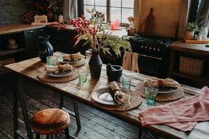 tavola servita per la cena. accogliente cucina interna. posate e tovaglioli in tavola per gli ospiti. colazione in famiglia. ora di pranzo. nessuno. foto