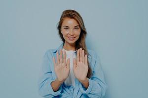 giovane bella donna in abiti casual in piedi e tenendo entrambe le mani foto