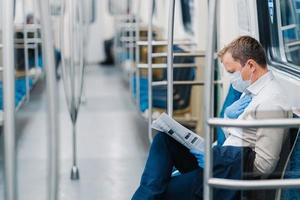 l'uomo malato ha problemi di respirazione, tiene la mano sul petto, viaggia in metropolitana, indossa maschera medica e guanti di gomma. pandemia di coronavirus. forte diminuzione del traffico passeggeri a causa della quarantena foto