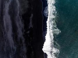 islanda spiaggia di sabbia nera con onde enormi a reynisfjara vik. foto