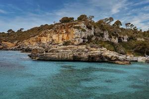 alberi su scogliere rocciose sul bellissimo paesaggio marino mediterraneo nell'isola contro il cielo foto
