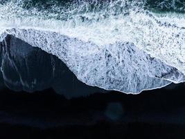 islanda spiaggia di sabbia nera con onde enormi a reynisfjara vik. foto