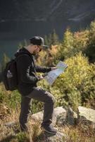 giovane viaggiatore con mappa e zaino foto