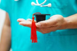 donna asiatica medico che tiene il cappello di laurea in ospedale, concetto di educazione medica. foto