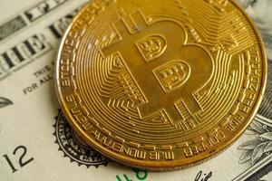 bitcoin dorato su banconote in dollari statunitensi soldi per affari e commerciali, valuta digitale, criptovaluta virtuale, tecnologia blockchain. foto