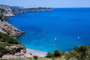 bellissima spiaggia con acqua molto pulita e azzurra sul mar mediterraneo nell'isola di ibiza, in spagna foto